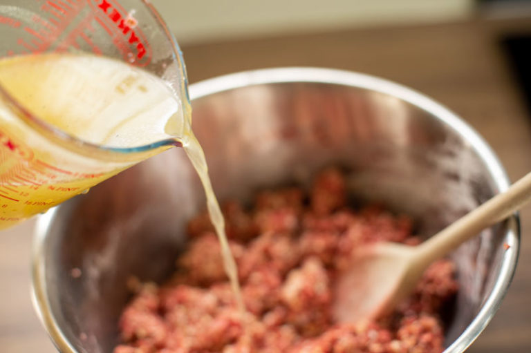 adding stock to mixing bowl
