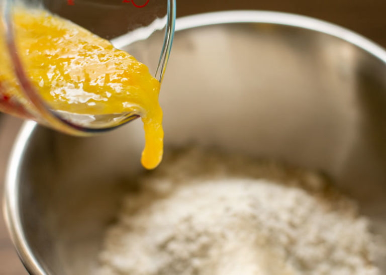 adding a beaten egg to a bowl