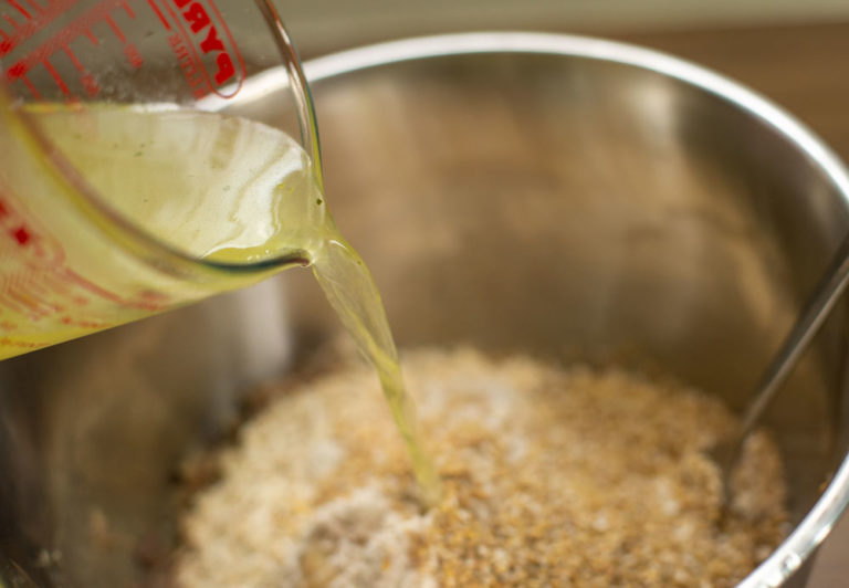adding broth to mixing bowl