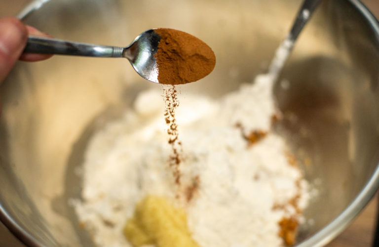 adding cinnamon to mixing bowl