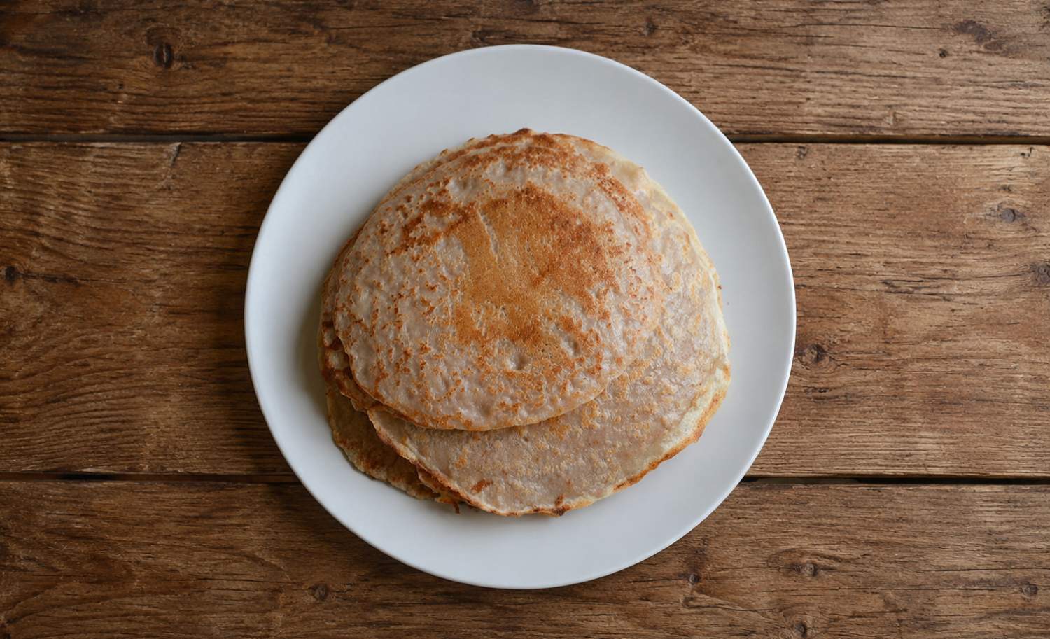 pancakes for dogs recipe freshly made pancakes sitting on a wooden worktop